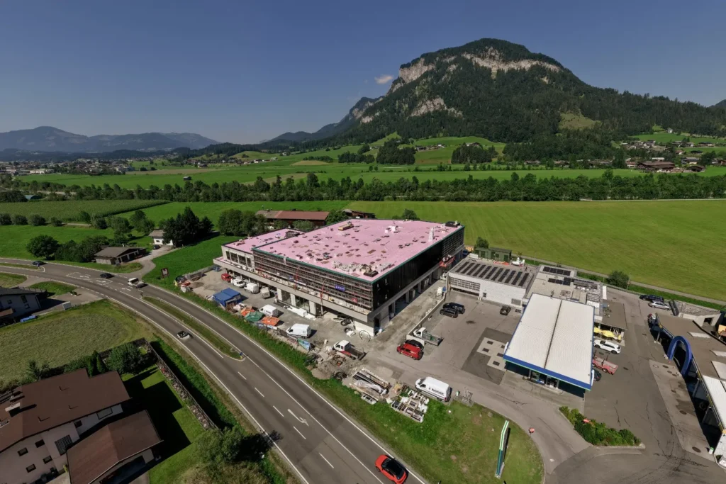 Luftaufnahme der SINN.CITY Baustelle in Kirchdorf mit dem neuen Auto-Hub vor Bergkulisse