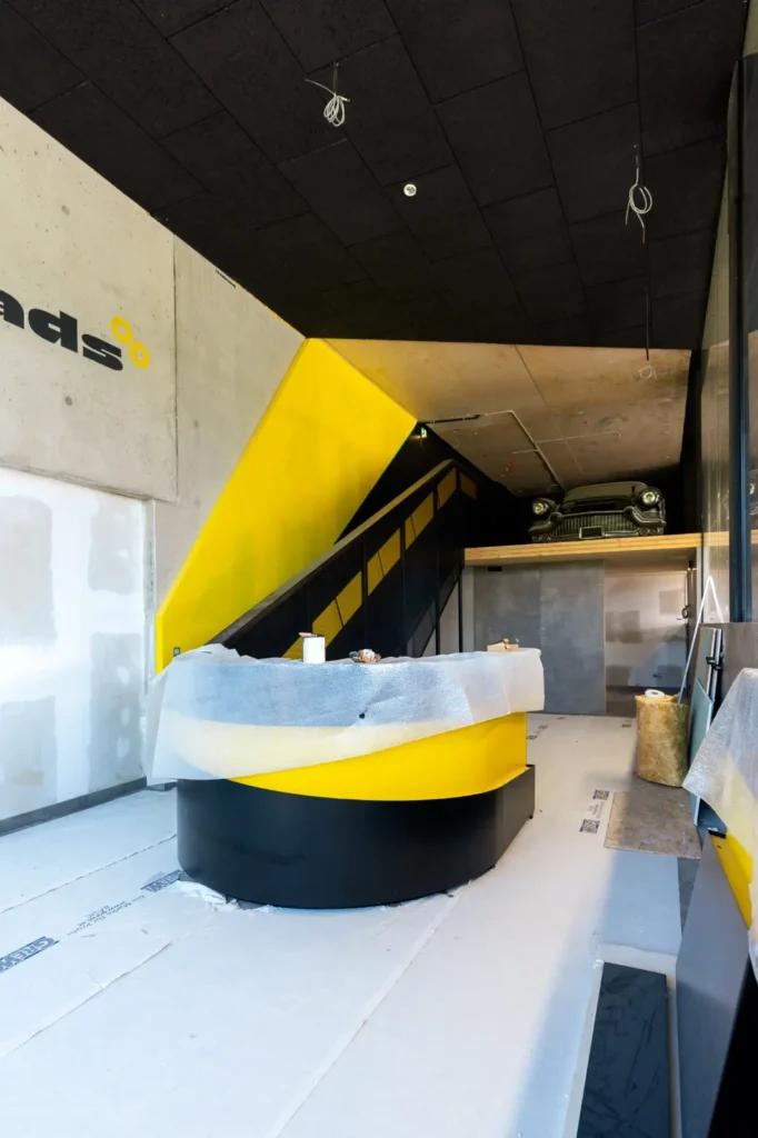 Empfangsbereich von GEARHEADS im Industrial Look mit gelb-schwarzem Design und Cadillac